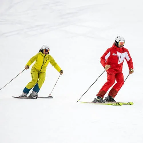 Skiers in different suits on the snow