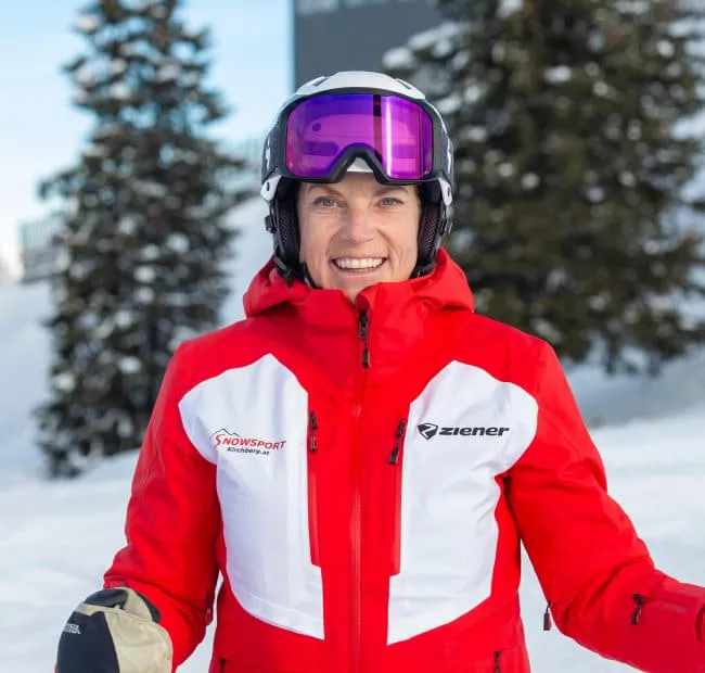 Skiing enthusiast in a red jacket smiling outdoors