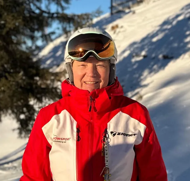 Person in ski gear smiling on snowy slope