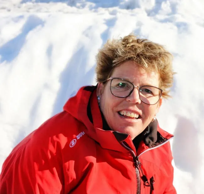 Person in red jacket smiling on snow