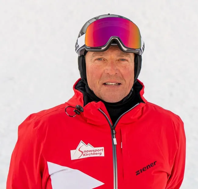 Skier in red jacket against snow-covered background