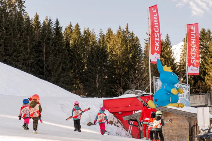 Kinder mit Skiern bei der Schneeschule in Kirchberg