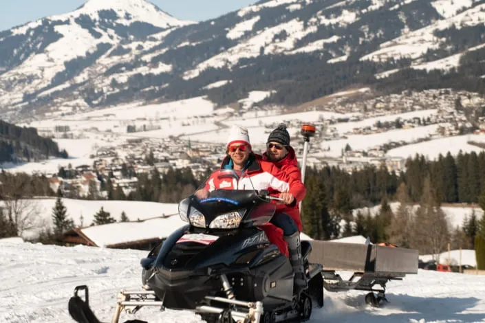Zwei Personen auf einem Schneemobil in Kirchberg.