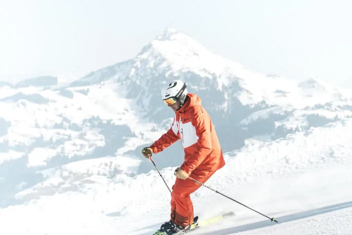 Skifahrer auf der Piste in Kirchberg, schneebedeckte Berge